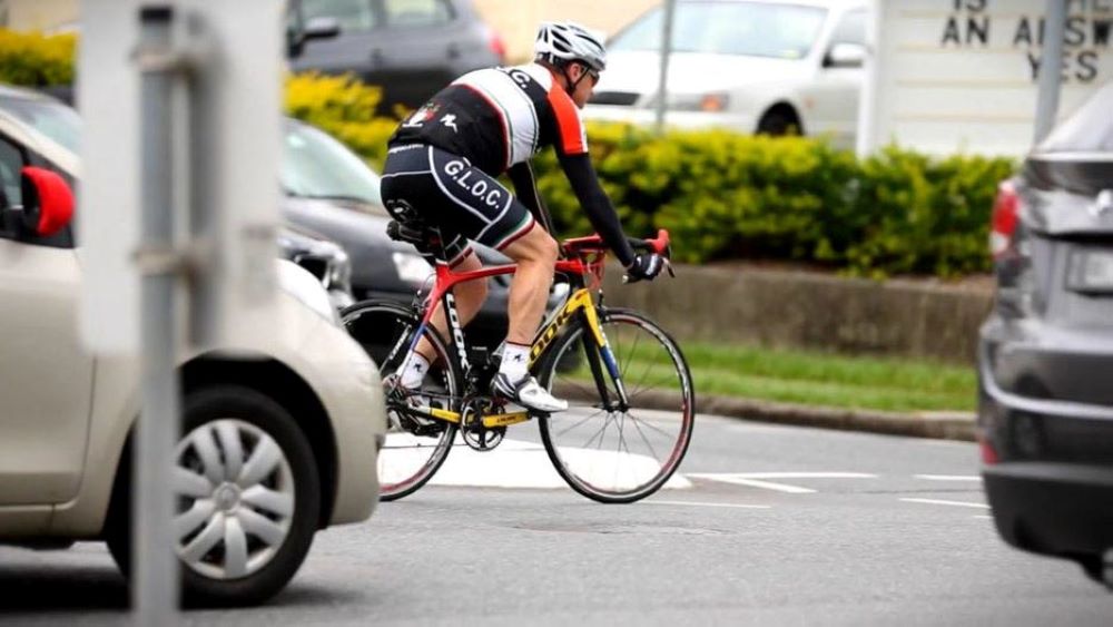 Cyclist on main road with cars