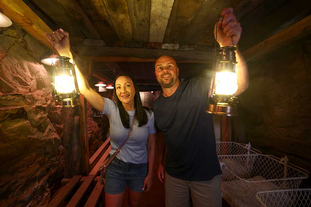 Two people holding lanterns on the Mount Isa Underground Mine Tour