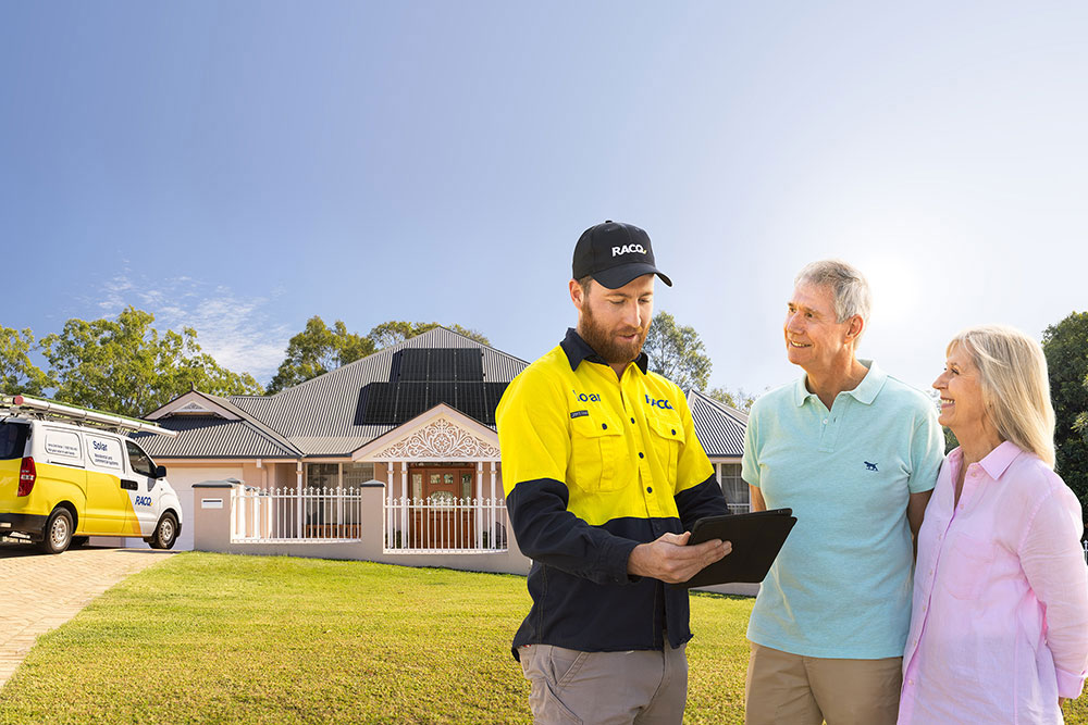RACQ solar installer with a couple in front of their house.