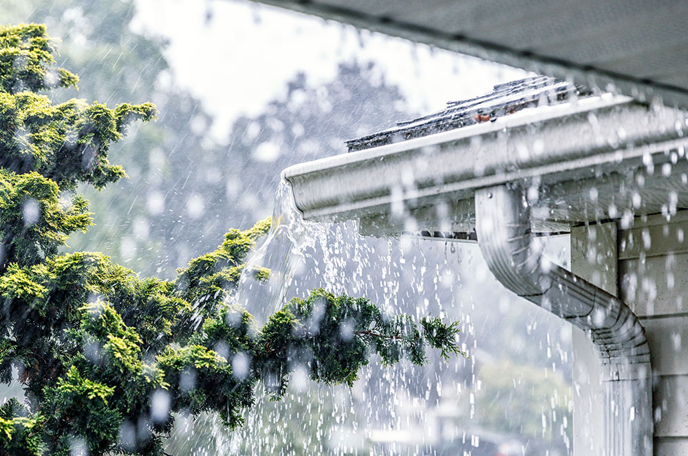 Gutter overflowing in heavy rain.
