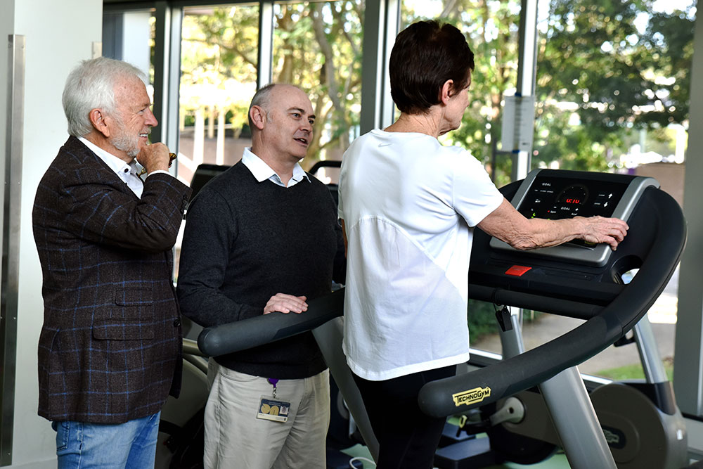 Researchers looks at a woman working out on an excercise bike.