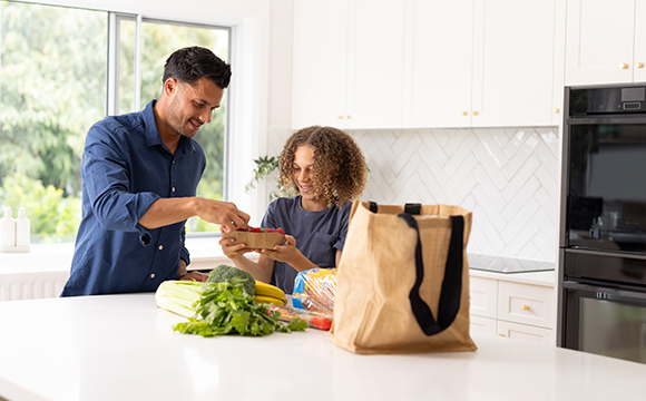 father and child unpacking groceries in kitchen